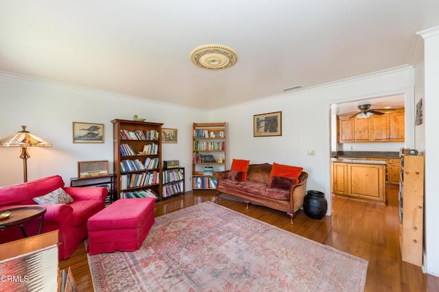 living room featuring wood finished floors, visible vents, and crown molding