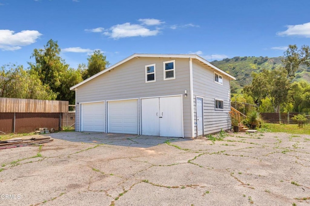 detached garage featuring fence