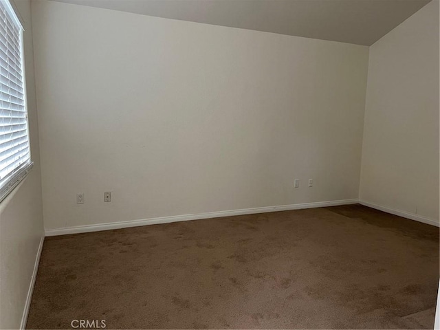 carpeted spare room with baseboards
