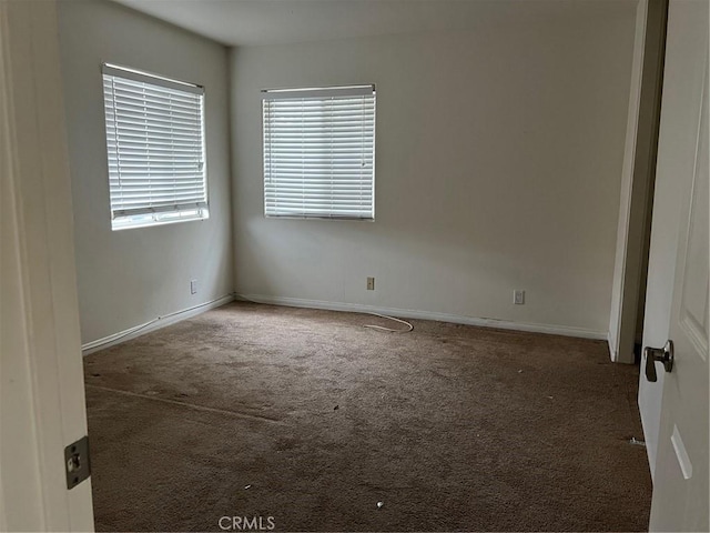 carpeted spare room with baseboards