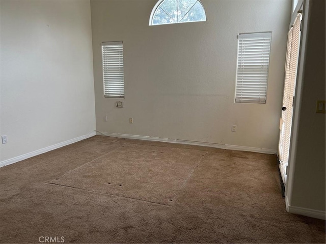 carpeted empty room with baseboards