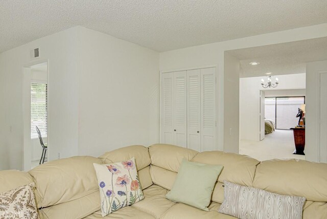 living room with a chandelier, visible vents, and a textured ceiling