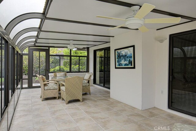sunroom / solarium featuring a ceiling fan and outdoor dining area