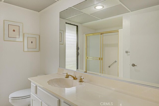 bathroom featuring toilet, a shower stall, and vanity