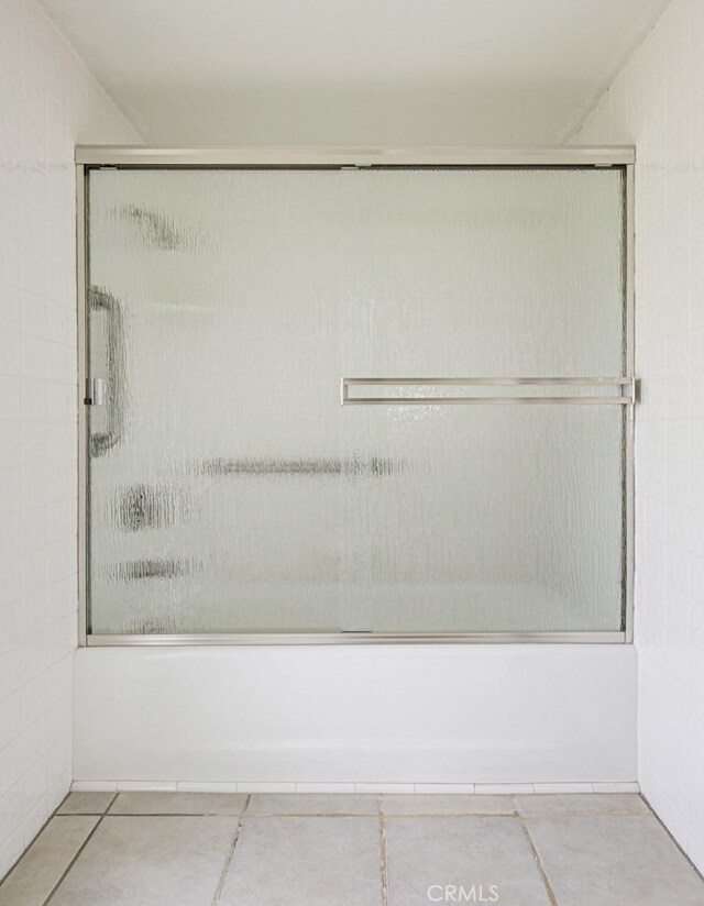 full bathroom featuring tile patterned floors and shower / bath combination with glass door