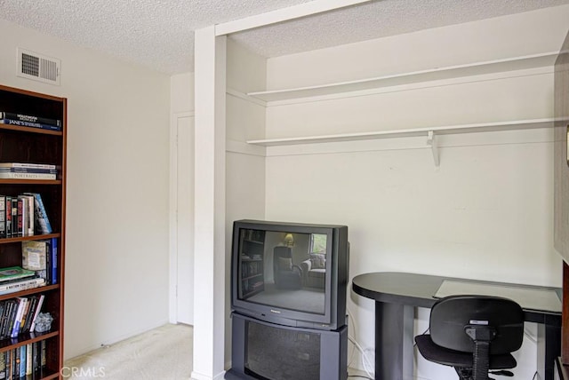 carpeted home office featuring a textured ceiling and visible vents