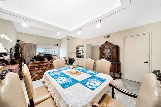 dining space featuring track lighting, visible vents, and light carpet