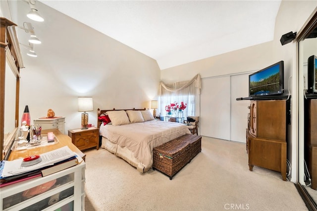 carpeted bedroom featuring lofted ceiling and a closet