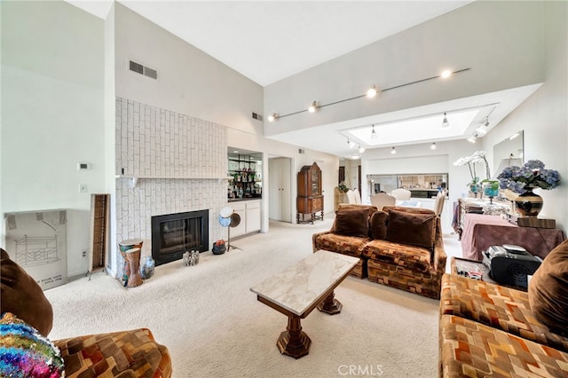 living area with rail lighting, carpet, visible vents, and a tiled fireplace