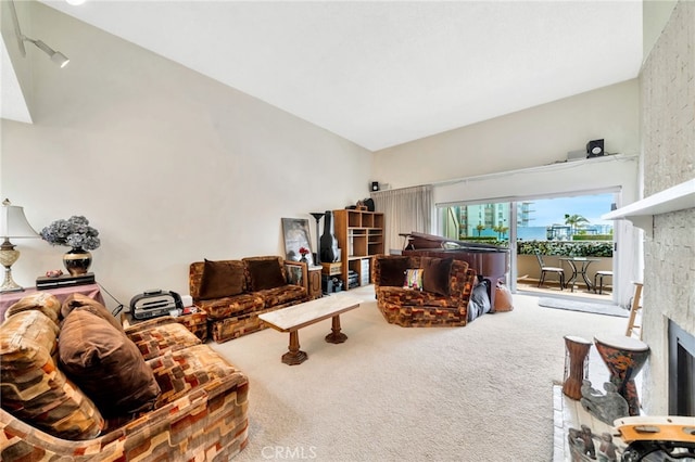 living area with lofted ceiling, carpet, and a fireplace
