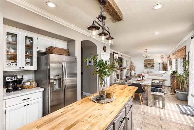 kitchen with crown molding, wooden counters, and stainless steel fridge with ice dispenser