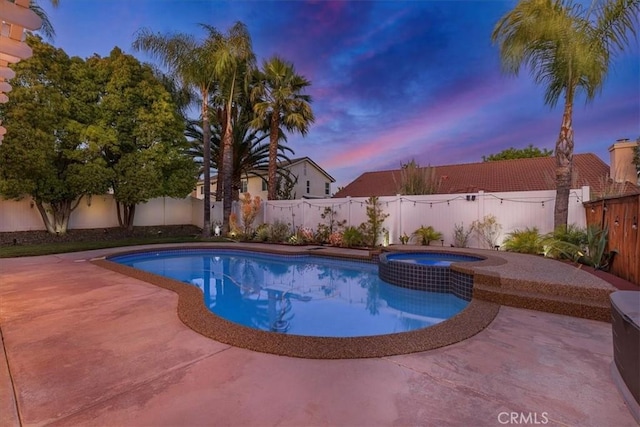 pool at dusk featuring a fenced backyard, a patio, and a pool with connected hot tub
