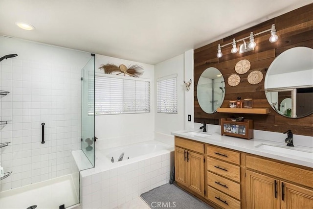 bathroom with a shower stall, a sink, and a bath