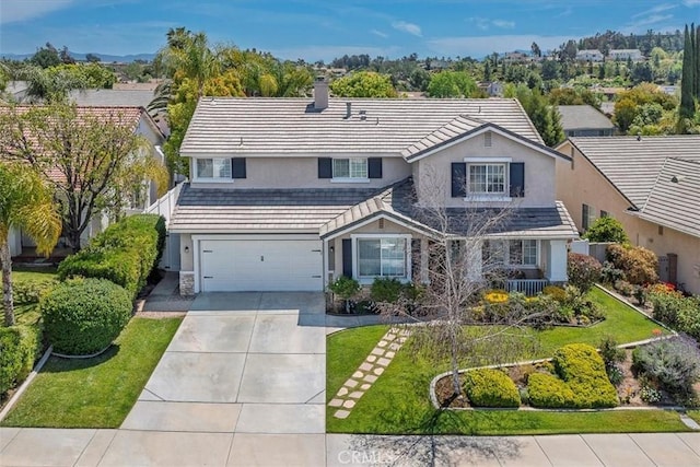 traditional-style house with concrete driveway, stucco siding, a chimney, and a garage