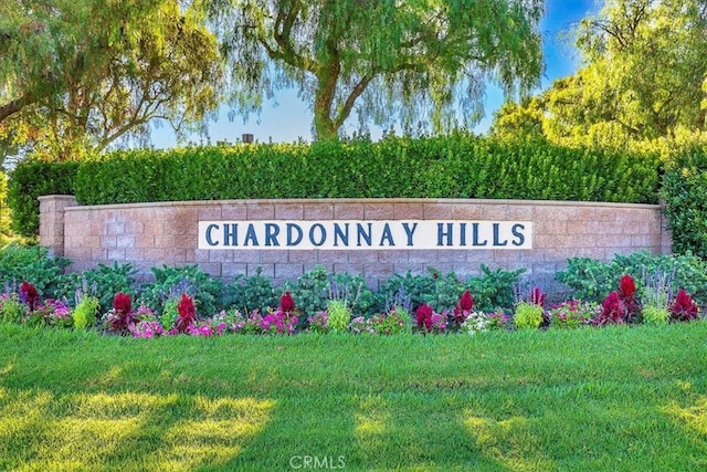 community / neighborhood sign featuring a lawn