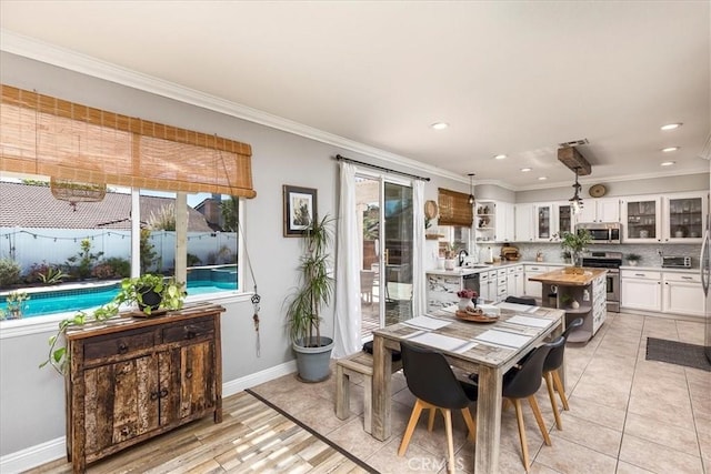 dining space with crown molding, recessed lighting, and baseboards