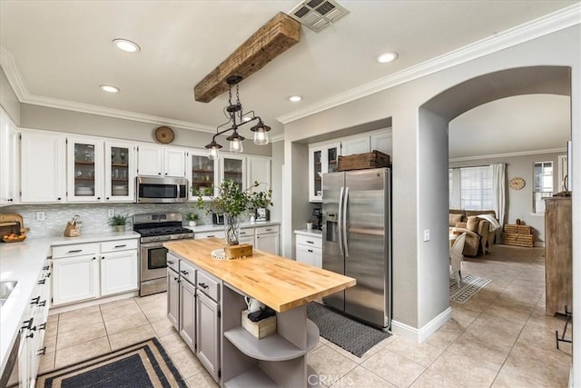 41028 Promenade Chardonnay Hls, Temecula, CA 92591 - kitchen with appliances with stainless steel finishes, butcher block countertops, open shelves, arched walkways, and backsplash