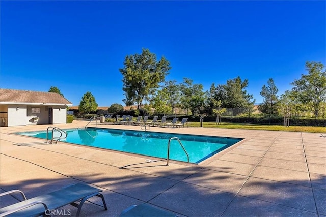 pool featuring fence and a patio area