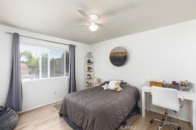 bedroom with a ceiling fan, baseboards, and wood finished floors