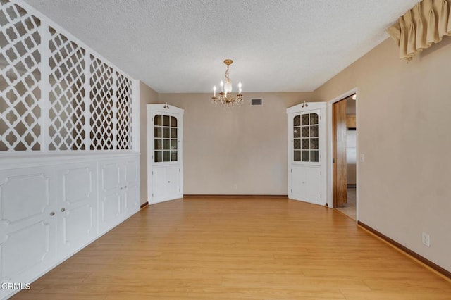 1530 Calle Portada, Camarillo, CA 93010 - unfurnished dining area with a textured ceiling, a chandelier, light wood-type flooring, baseboards, and visible vents