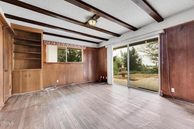 1530 Calle Portada, Camarillo, CA 93010 - spare room with beamed ceiling, wood walls, a textured ceiling, and wood-type flooring