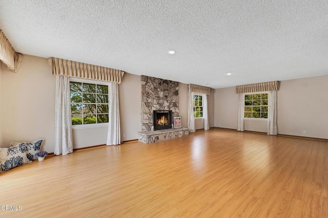 1530 Calle Portada, Camarillo, CA 93010 - unfurnished living room featuring wood finished floors, a textured ceiling, a fireplace, baseboards, and recessed lighting
