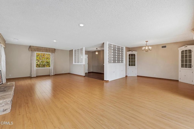 1530 Calle Portada, Camarillo, CA 93010 - unfurnished living room featuring wood finished floors, a textured ceiling, a notable chandelier, and visible vents
