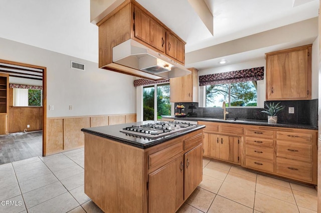 1530 Calle Portada, Camarillo, CA 93010 - kitchen with stainless steel gas cooktop, a wainscoted wall, a sink, dark countertops, and visible vents