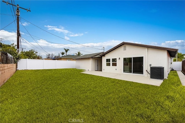 back of property with a patio area, a yard, central air condition unit, and stucco siding