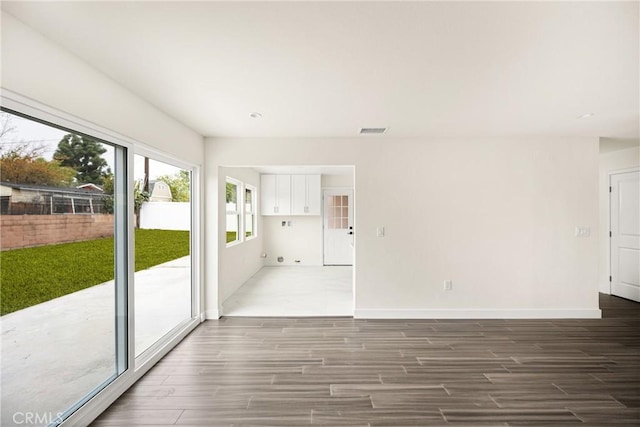 unfurnished room with visible vents, baseboards, and wood tiled floor