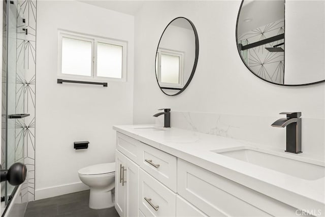 full bathroom featuring walk in shower, a sink, double vanity, and toilet