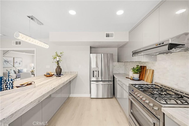 12 Whitewood Way, Irvine, CA 92612 - kitchen featuring visible vents, light wood-type flooring, under cabinet range hood, appliances with stainless steel finishes, and backsplash
