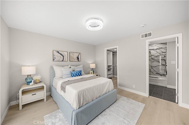 12 Whitewood Way, Irvine, CA 92612 - bedroom with visible vents, baseboards, light wood-type flooring, a spacious closet, and ensuite bath