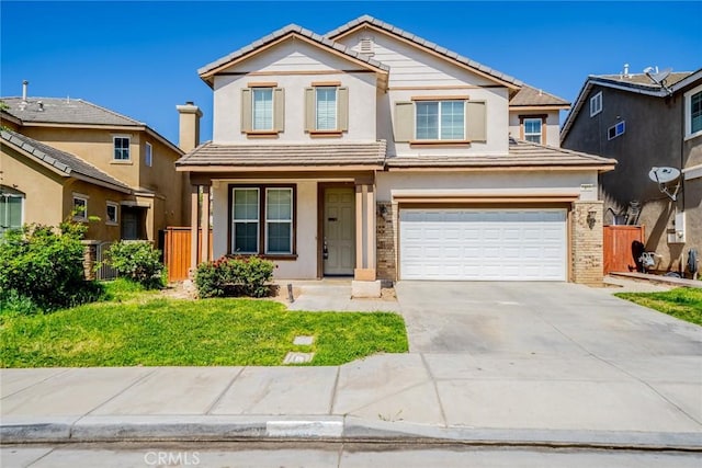 traditional-style house featuring a tiled roof, concrete driveway, brick siding, a garage, and stucco siding