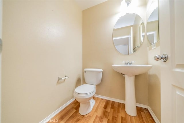 3882 Strand Way, Perris, CA 92571 - bathroom with wood finished floors, toilet, baseboards, and a sink