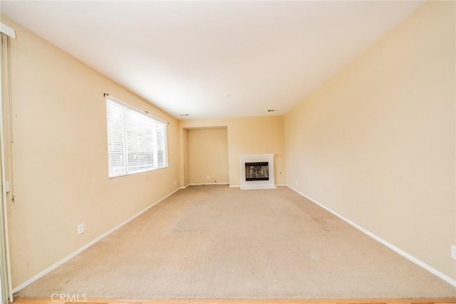 3882 Strand Way, Perris, CA 92571 - unfurnished living room with a glass covered fireplace, light carpet, and baseboards