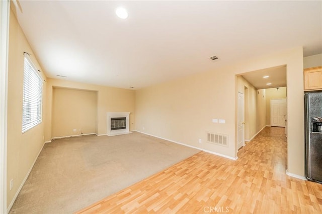 3882 Strand Way, Perris, CA 92571 - unfurnished living room with a glass covered fireplace, baseboards, light wood finished floors, and recessed lighting