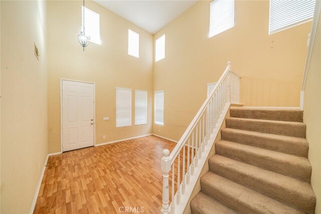 3882 Strand Way, Perris, CA 92571 - foyer featuring wood finished floors, stairway, baseboards, and a towering ceiling