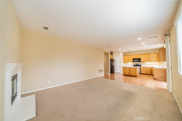 3882 Strand Way, Perris, CA 92571 - unfurnished living room with light carpet, baseboards, recessed lighting, healthy amount of natural light, and a glass covered fireplace