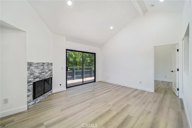 7314 Quill Dr Unit 155, Downey, CA 90242 - unfurnished living room with a fireplace, light wood-type flooring, beam ceiling, and high vaulted ceiling