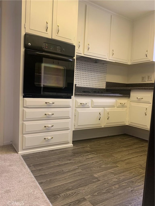 61 Calle Cadiz Unit Q, Laguna Woods, CA 92530 - kitchen featuring oven, white cabinets, dark wood finished floors, and dark countertops