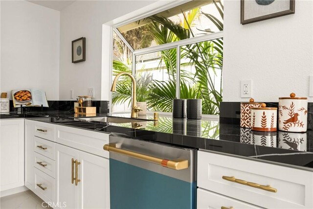 2122 Via Aguila, San Clemente, CA 92673 - kitchen with stainless steel dishwasher, dark countertops, white cabinetry, and a sink