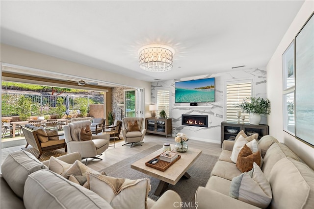 living area with wood finished floors, a fireplace, and a healthy amount of sunlight