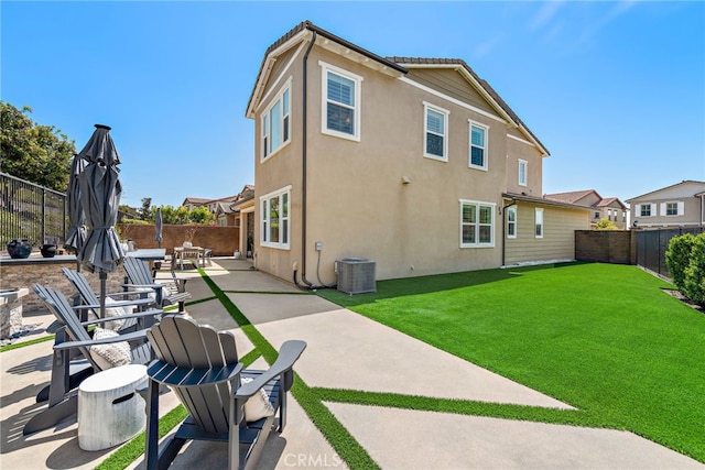 rear view of house featuring central air condition unit, a patio, stucco siding, a fenced backyard, and a lawn