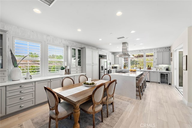 dining area featuring wine cooler, light wood-type flooring, visible vents, and recessed lighting