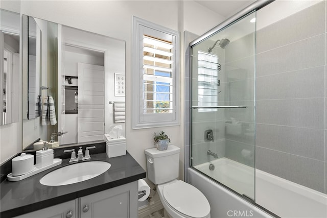 bathroom with vanity, toilet, shower / bath combination with glass door, and plenty of natural light