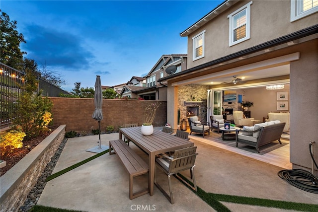 view of patio / terrace featuring an outdoor living space with a fireplace, outdoor dining area, and fence private yard