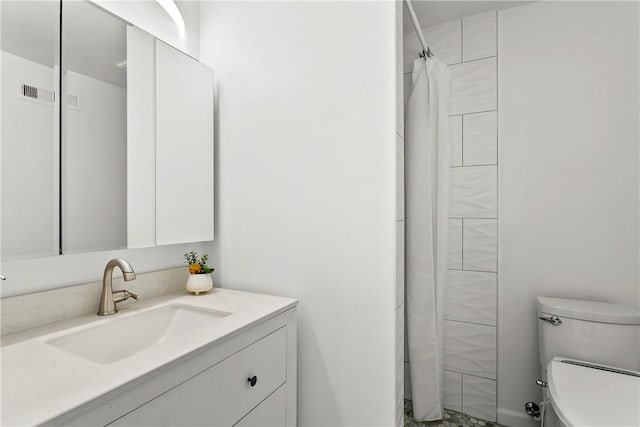 bathroom featuring vanity, a shower with curtain, toilet, and visible vents