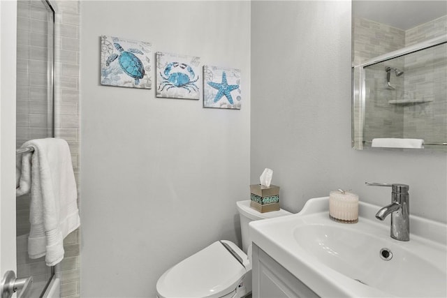 full bathroom with vanity, a tile shower, and toilet