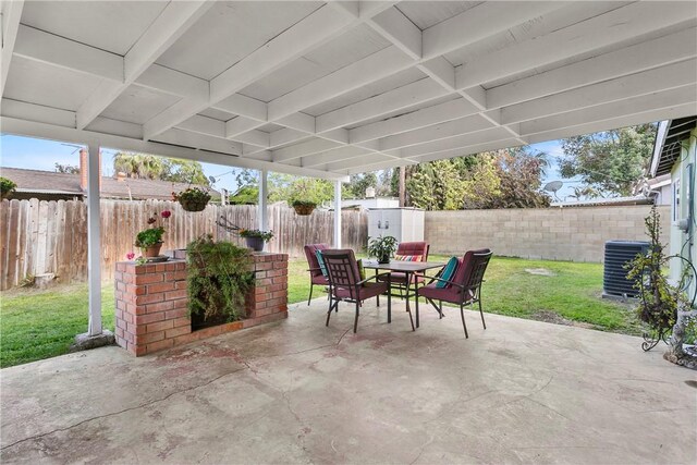 view of patio featuring outdoor dining area, a fenced backyard, central AC, and a shed
